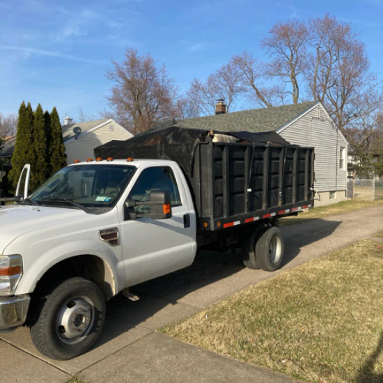Mack's Junk Removal truck at a residential property