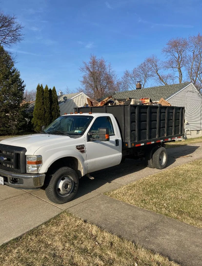 Mack's Junk Removal truck loaded at a residential property